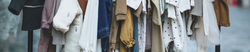 A rail of children's clothing on hangers