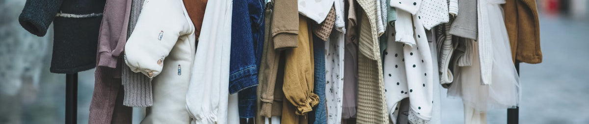 A rail of children's clothing on hangers
